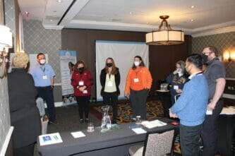 CATW 2022 attendees engaged in small group discussion.